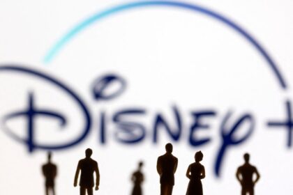 Toy Figures Of People Are Seen In Front Of The Displayed Disney Logo In This Illustration Taken Janu
