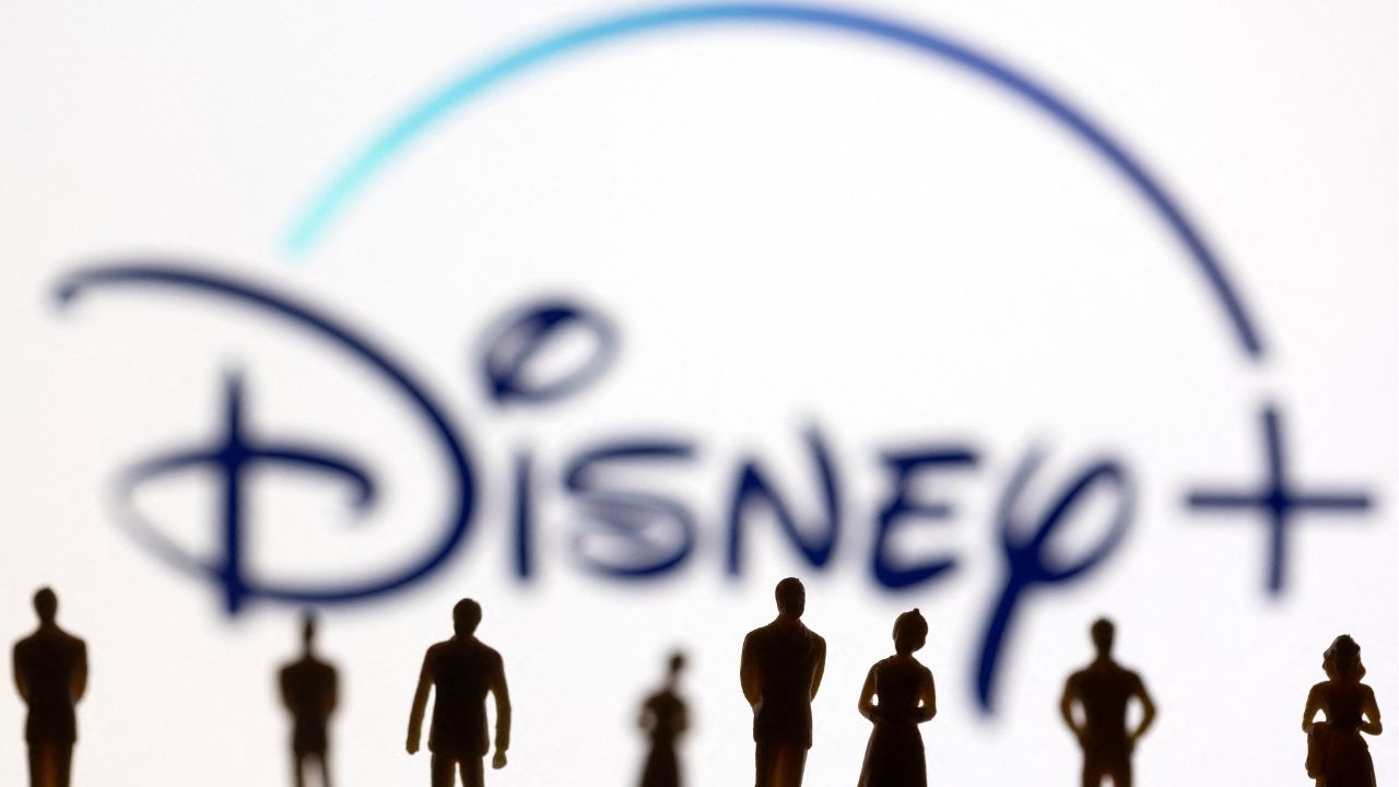 Toy Figures Of People Are Seen In Front Of The Displayed Disney Logo In This Illustration Taken Janu